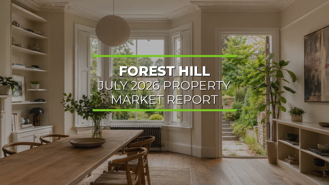 Bright modern dining room with large bay windows overlooking a lush garden. Wooden dining table with chairs sits in the center, surrounded by built-in shelves with decorative items and indoor plants. Natural light fills the space, highlighting elegant crown molding. Overlaid text reads ‘Forest Hill July 2026 Property Market Report.’