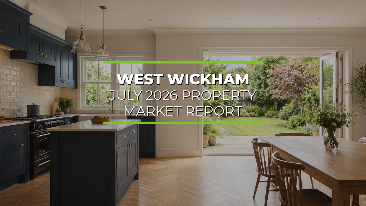 Bright modern kitchen with navy blue cabinetry and central island beneath pendant lights. Spacious dining area with wooden table and chairs opens through large glass doors to a lush garden with green grass and trees. Natural light enhances the inviting atmosphere. Overlaid text reads ‘West Wickham July 2026 Property Market Report.'