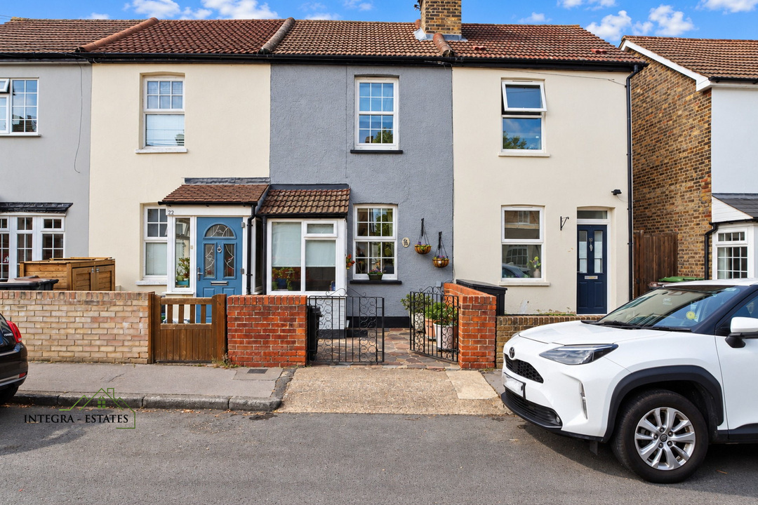 Front elevation of a terraced residential property with cream and grey rendered façades, blue front doors, small enclosed front gardens, and a white car parked on the street outside.